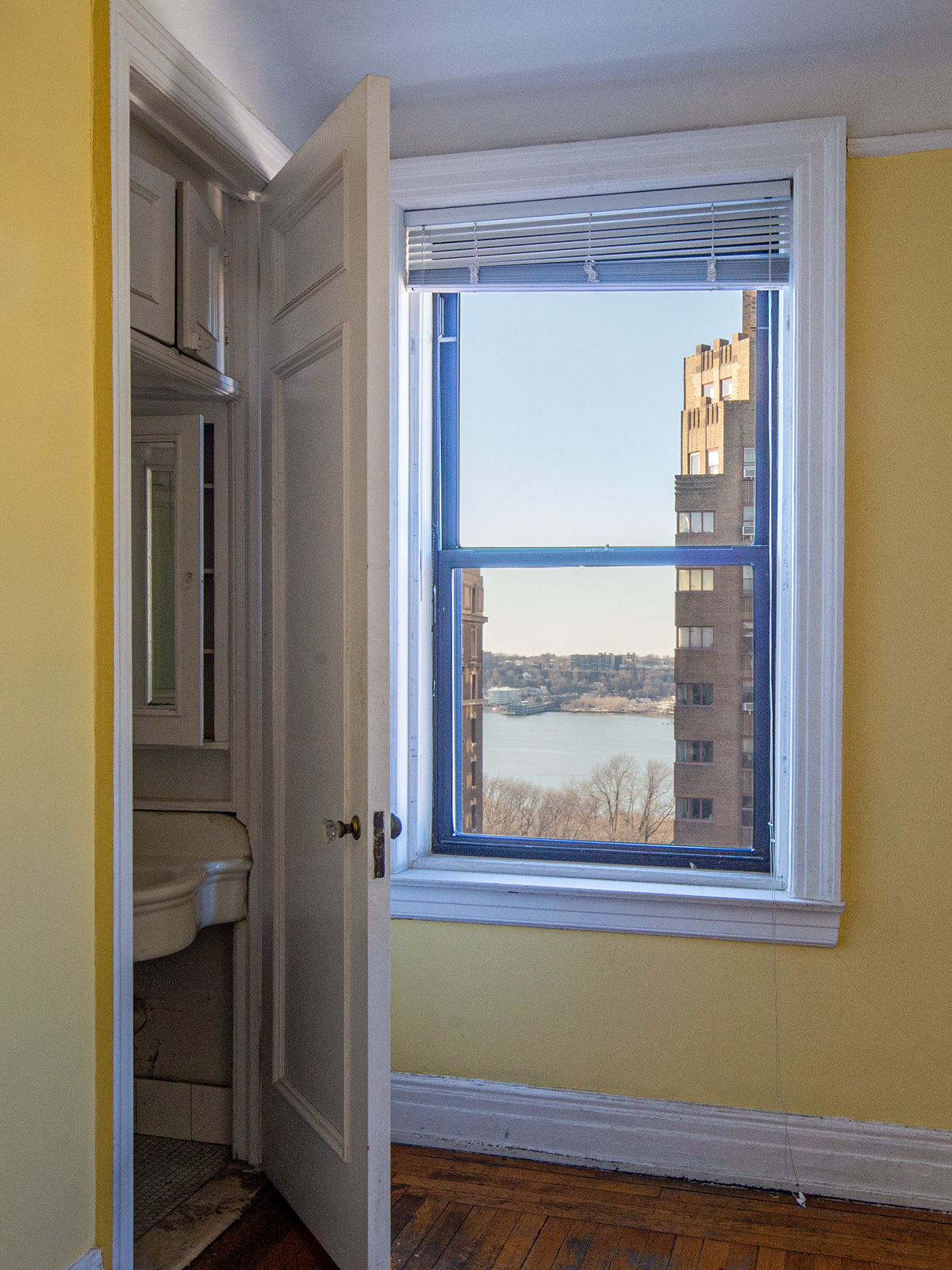 Before: The door to an original-construction sink closet blocks the western light because it is always left open; there is a porcelain sink and no storage.