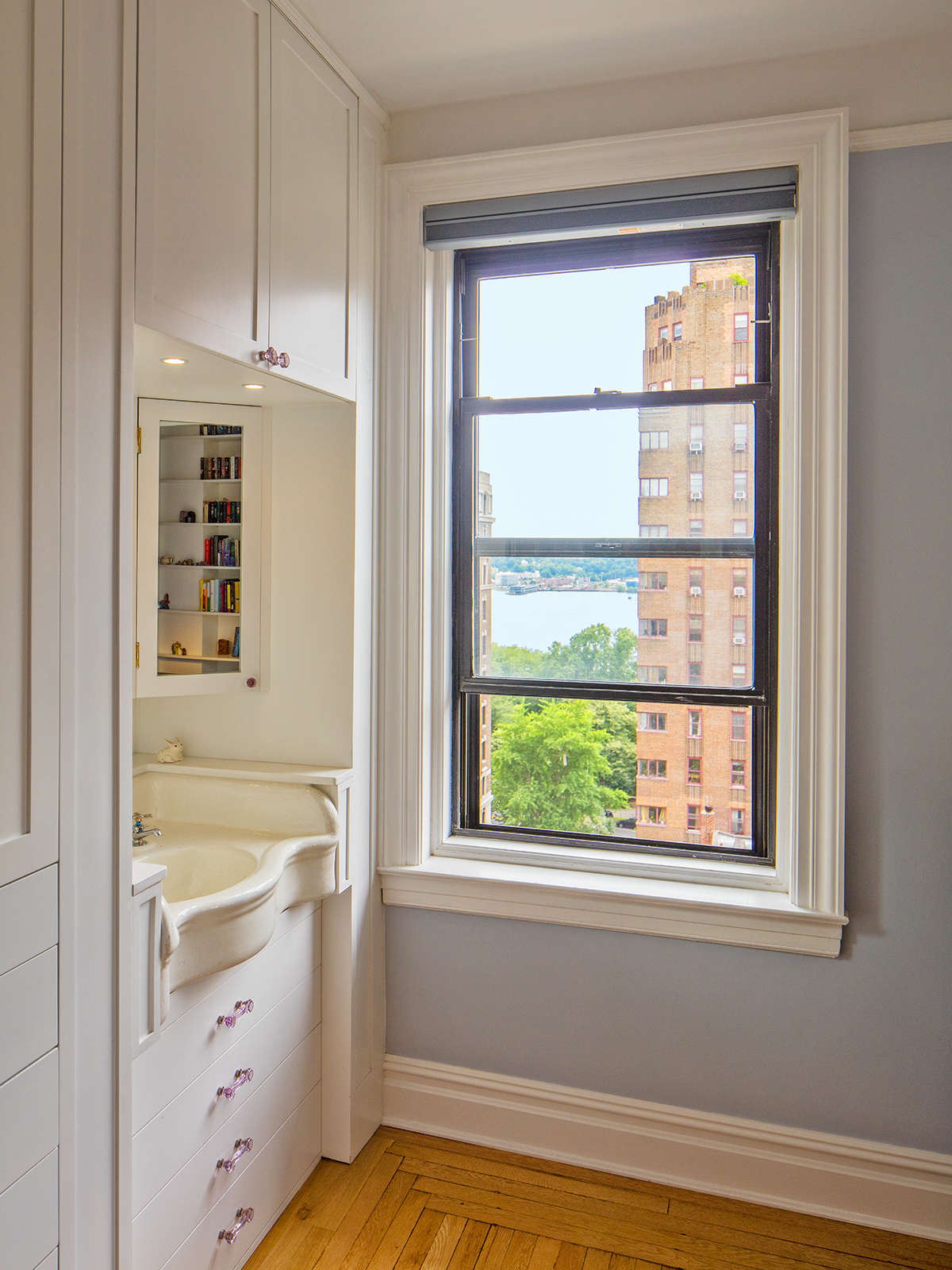 After: We removed the door to the sink closet to let in the Western light and featured the vintage. sink, replacing the plumbing, and adding storage above and below with purple vintage glass pulls