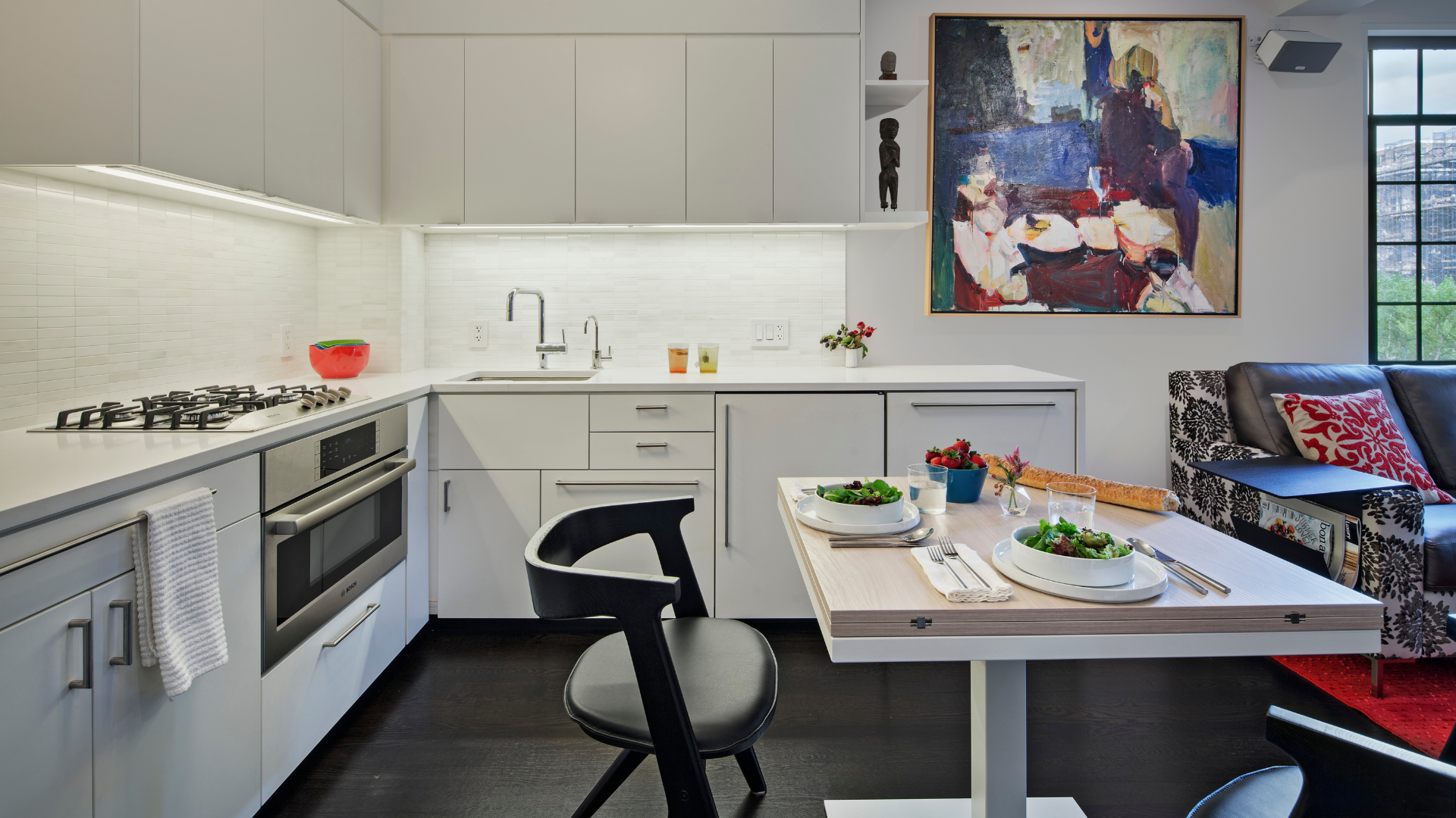 Sleek and compact white kitchen with cafe table and chairs