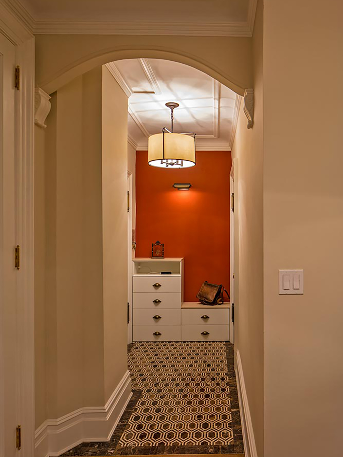 A hallway leading to a bathroom with an orange wall