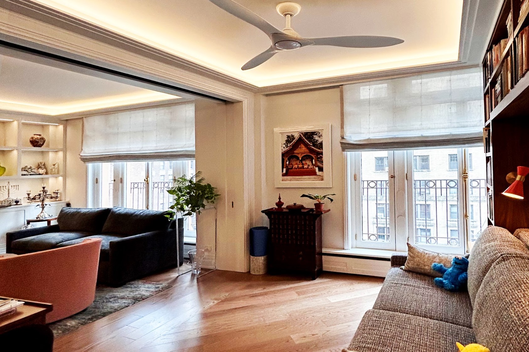 After: The wall dividing the home office (previously a bedroom) from the living room is now a triple-wide pocket door that unites the floor-to-ceiling windows in a wall of daylight. Both rooms have cove lighting to provide the option of light without glare.