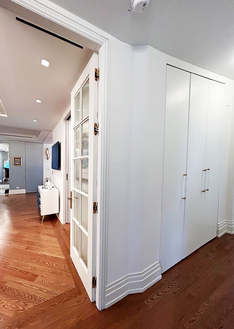 After: The corridor has been shortened, and a large glass-paned door opens to the entertaining space. The closet now has 3 doors to that all of its contents are easily accessible.