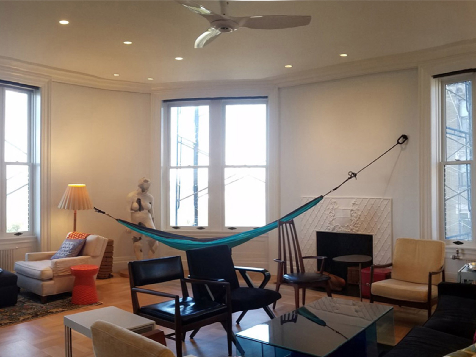 a hammock hangs in the middle of a living room