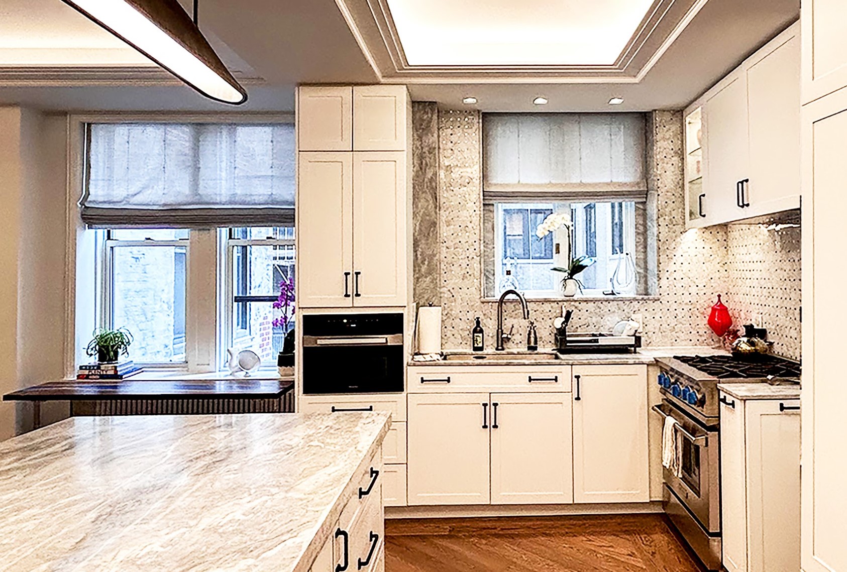 After: A large marble-topped island occupies the space where the wall between Kitchen and Dining Room used to be. Another window is now part of the Kitchen.