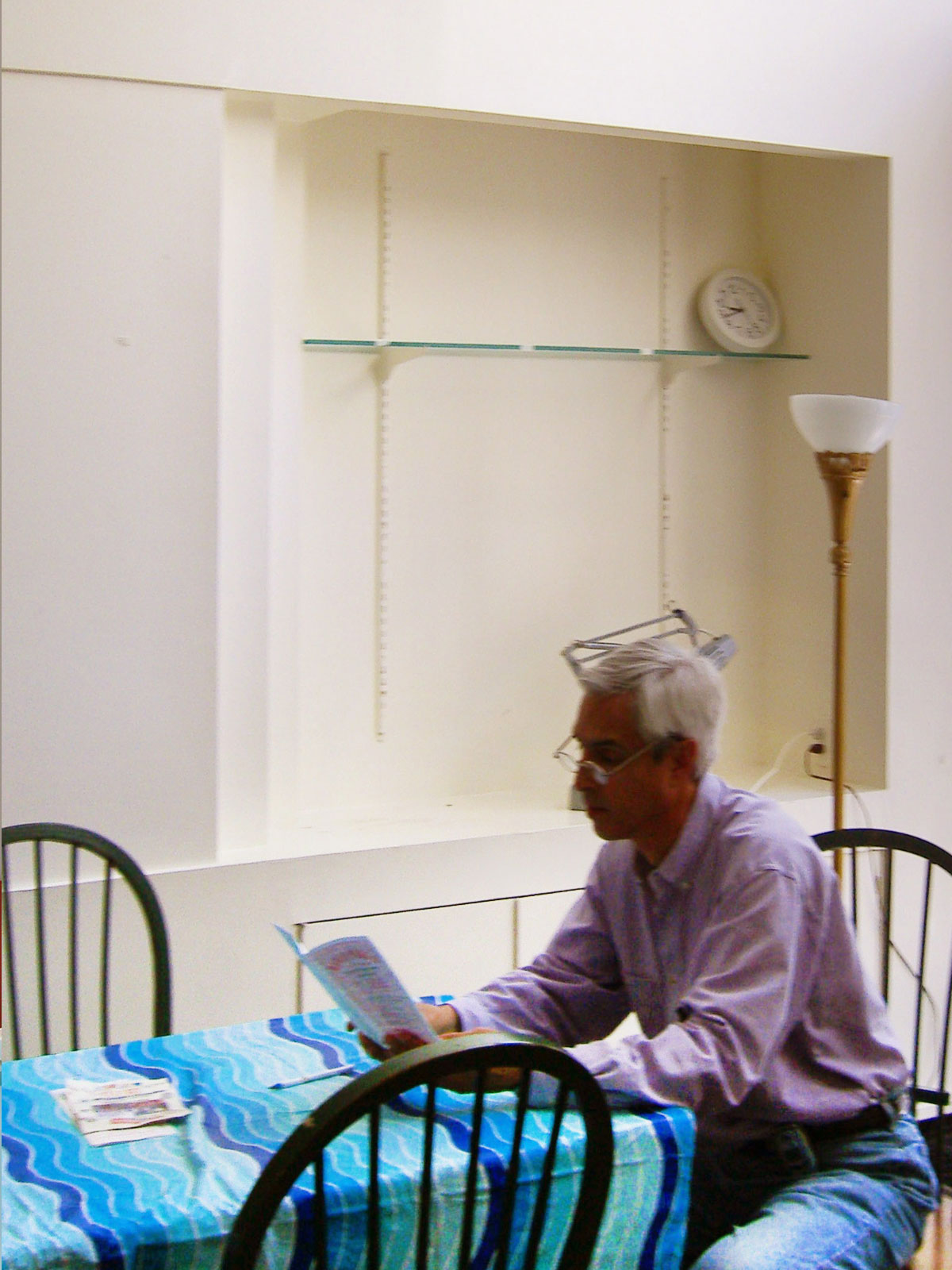 A man sitting at a table with a blue plastic covering in front of a sheetrock niche