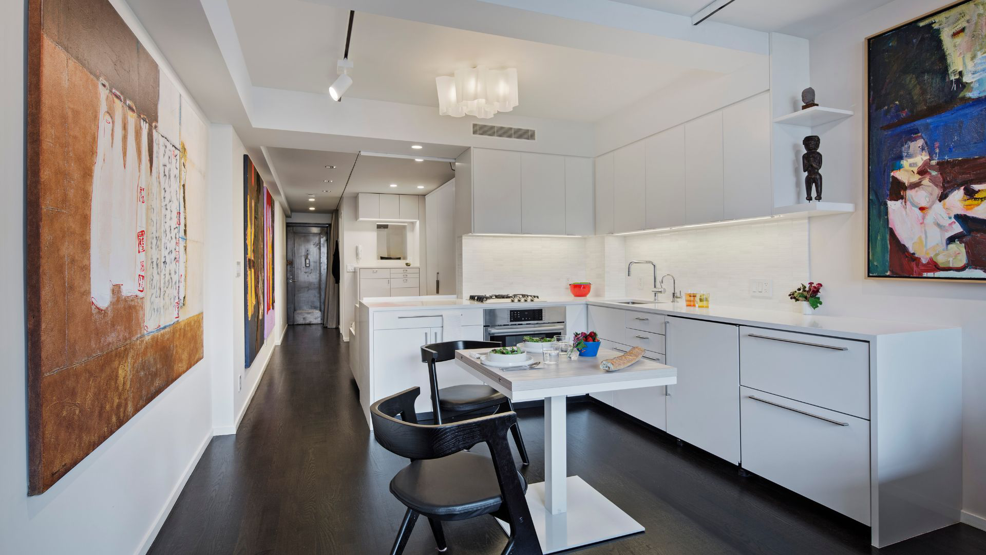 Looking the other way toward the front door, the all-white kitchen is below the counter, allowing your view to extend through the apartment.